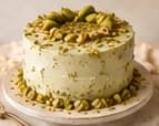 Pale green Pistachio Dream cake covered in crushed pistachios